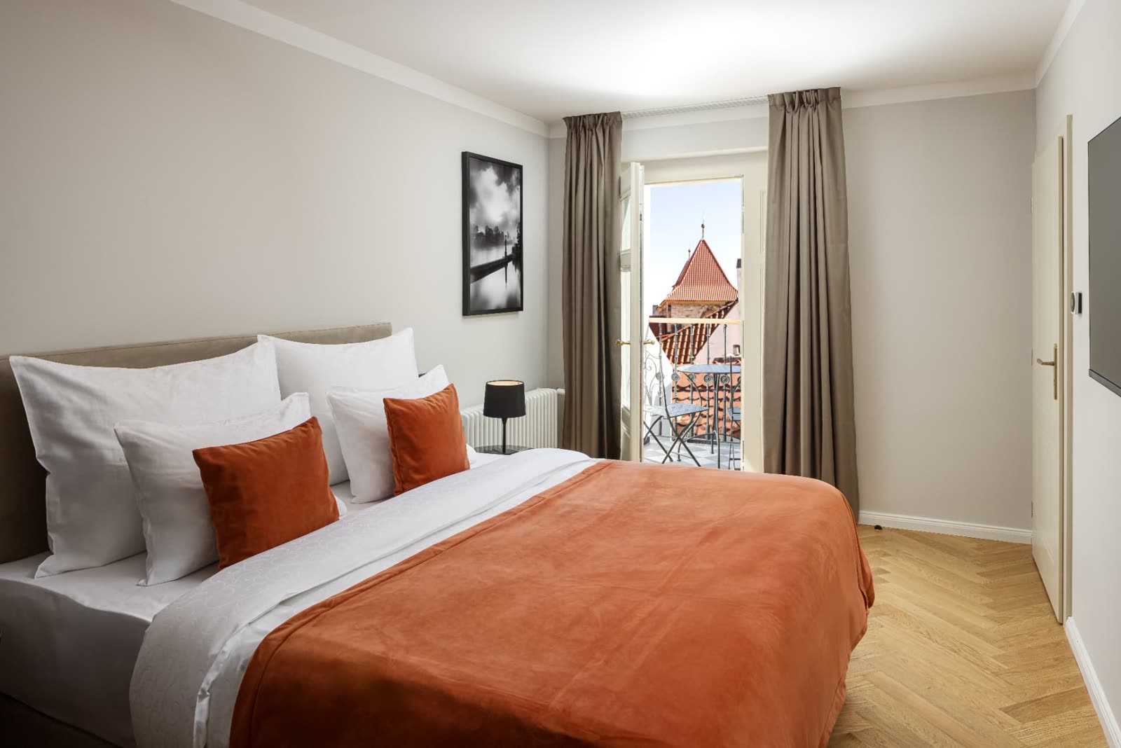 Double bedroom with balcony overlooking Prague rooftops
