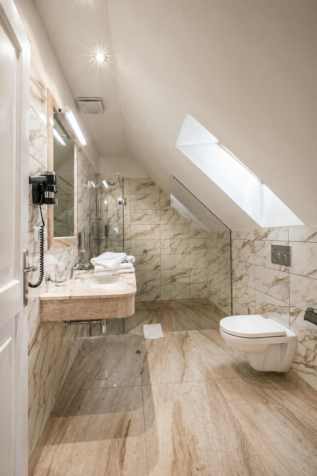 Attic bathroom with marble tiles and rain shower